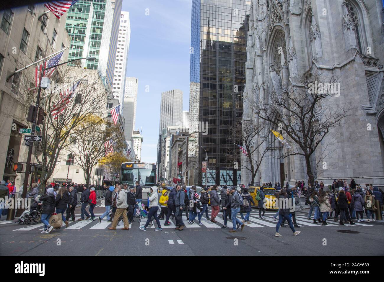 Guardando a nord fino la Quinta Avenue passato la Cattedrale di San Patrizio con la folla di turisti e amanti dello shopping in crosswalk sul Venerdì nero dando dei calci a fuori le vacanze Foto Stock