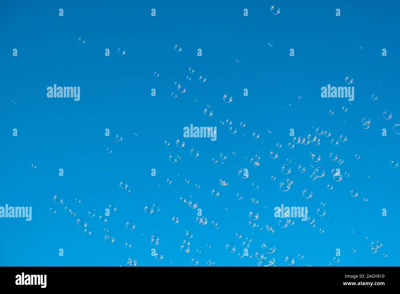Bolle di sapone battenti sul cielo azzurro sfondo, bolla concetto di flottazione Foto Stock