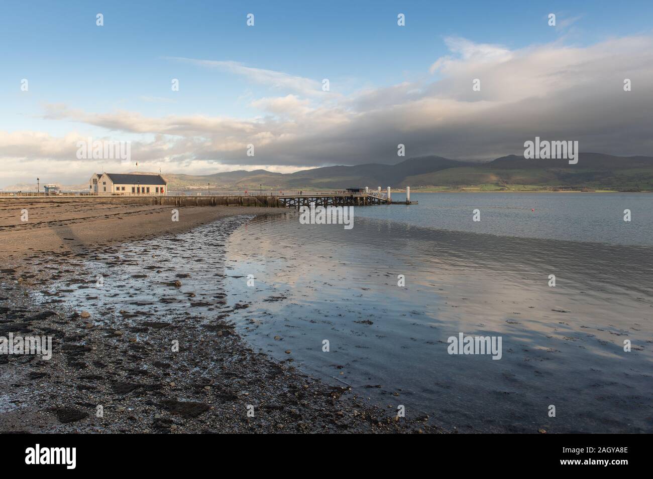 Beaumaris Pier, con la stazione di salvataggio, guardando attraverso Conwy Bay verso Manchester, Penmaenmar e Great Orme alla testa. Foto Stock