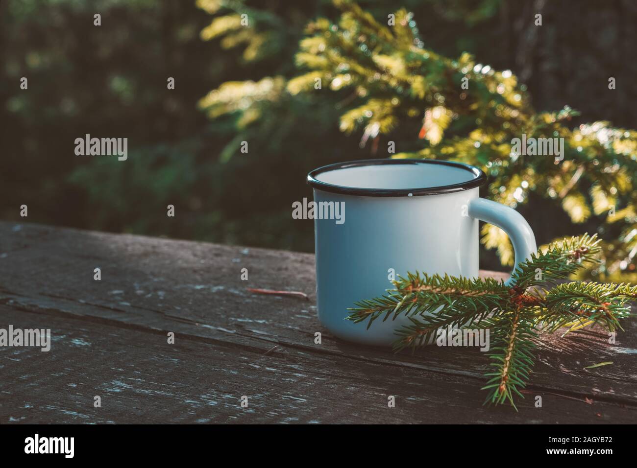 Smaltato tazza di caffè o di tè sulla tavola di legno nella Foresta estate all'aperto. Foto Stock