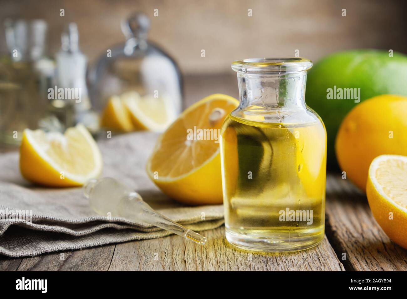 Bottiglia di agrumi Olio essenziale di limone e agrumi sul tavolo. Foto Stock