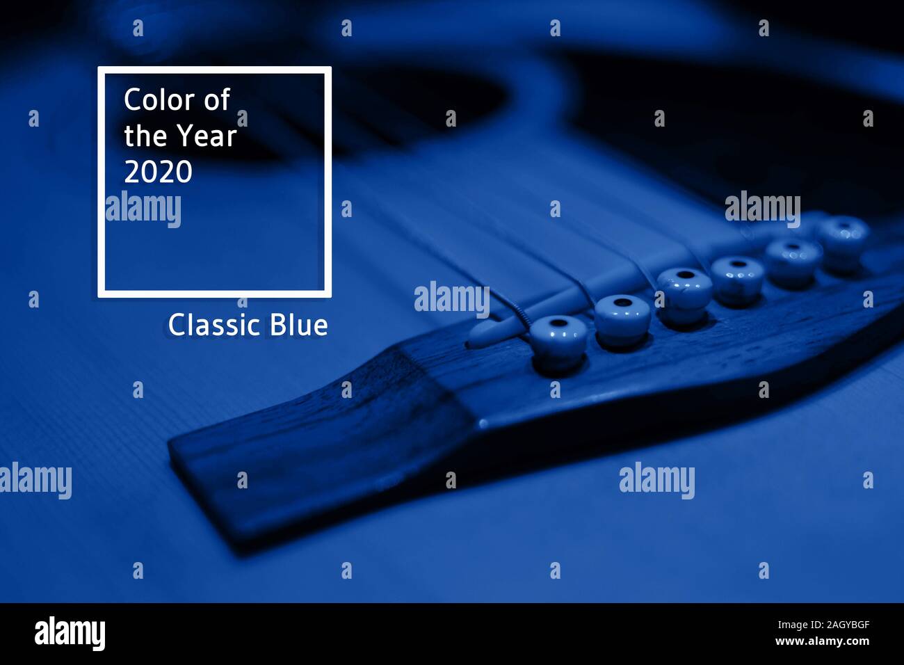 Frammento di corpo e stringhe di un classico chitarra acustica in una stanza buia sotto la luce blu. Selective soft focus. Principale tendenza colore del 2020. Foto Stock