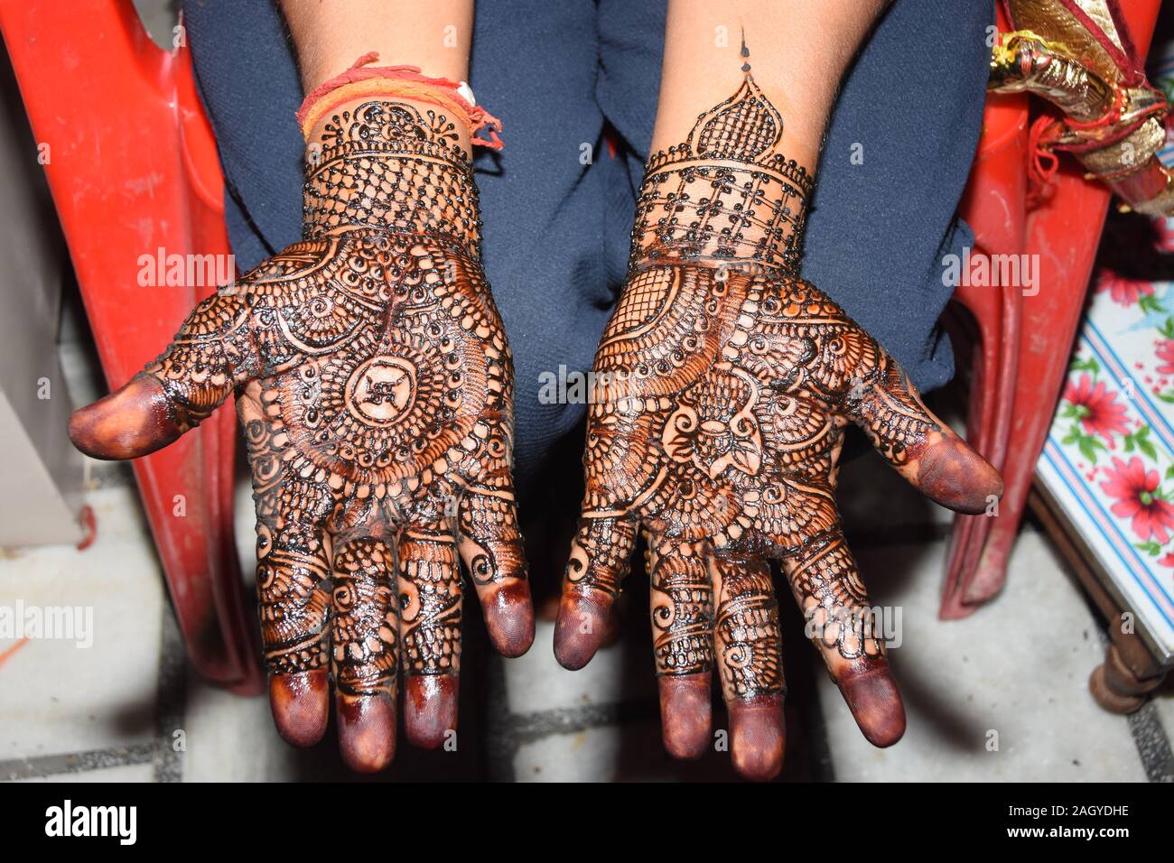 Sposa indiana per mostrare il design mehendi nelle sue mani da parte dello sposo Foto Stock