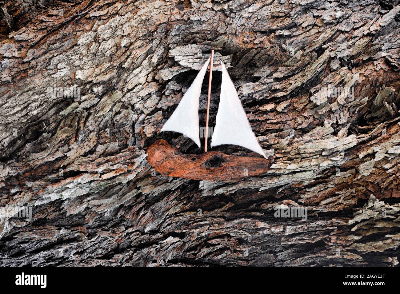 In legno realizzati a mano sulla nave di corteccia di albero sullo sfondo. Corteccia di sfondo astratto. Sullo sfondo della costruzione navale. In legno originali opere d'arte. Fatte a mano e concetto di hobby. Arte concettuale sullo sfondo Foto Stock