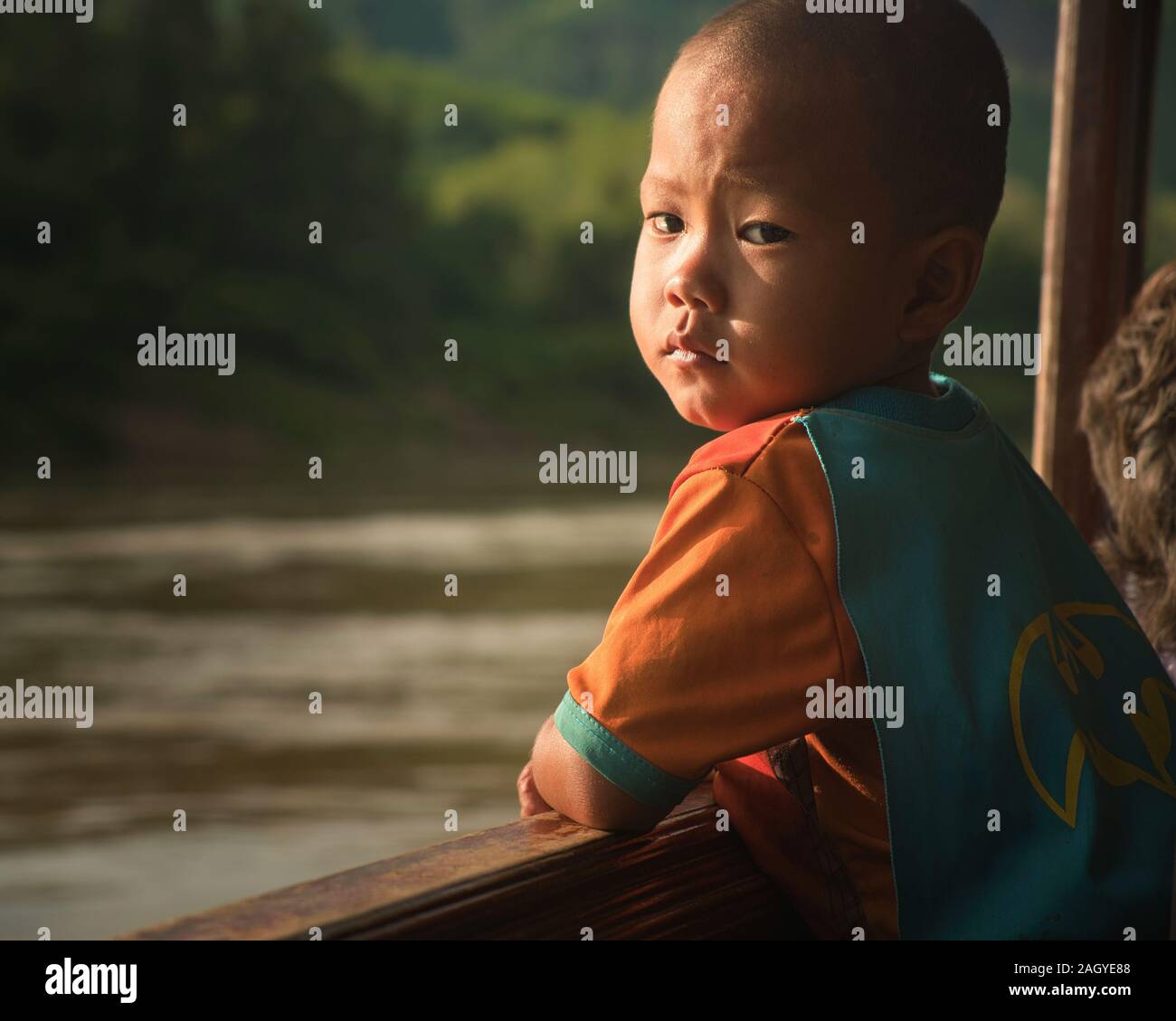 Ritratto di un giovane ragazzo laotiano sul fiume Mekong in barca, Laos, Sud Est asiatico Foto Stock