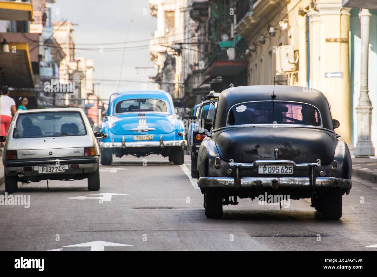 Una classica coppia di vintage, Classic, vetture a partire dagli anni cinquanta, guidando lungo la strada; nella città vecchia parte della città di Havana, Cuba Foto Stock