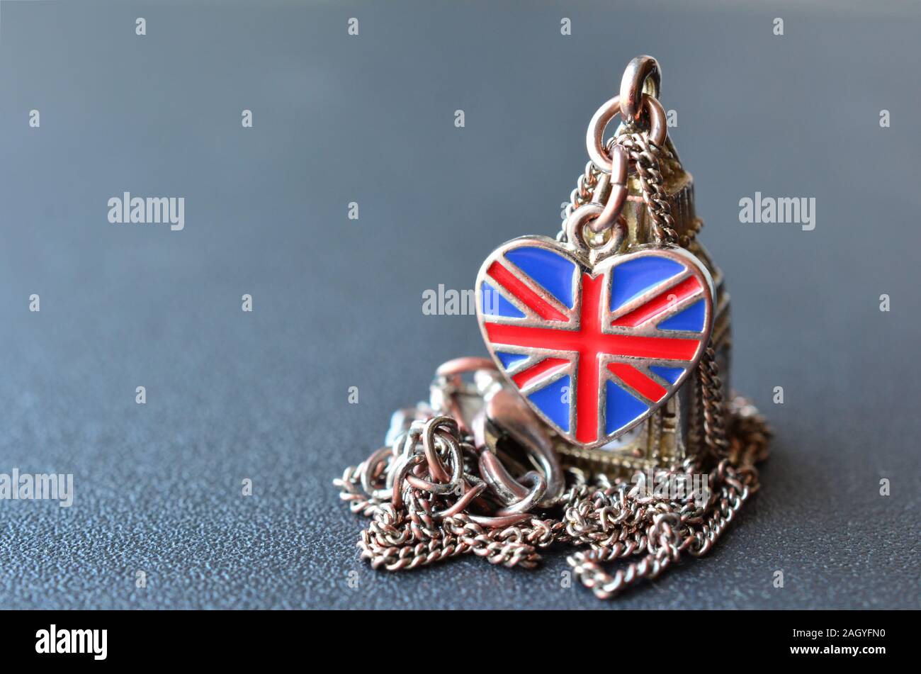 Souvenir da Gran Bretagna - collana con pendente di Big Ben figura a forma di cuore bandiera britannica grigio sulla superficie metallica con profondità di campo Foto Stock