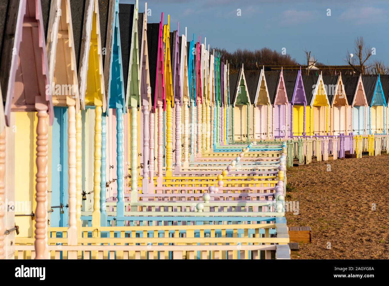 In legno colorato capanne sulla spiaggia a West Mersea, Mersea Island, Essex, Regno Unito durante una pausa nell'inverno. Dicembre pomeriggio. Colori brillanti Foto Stock