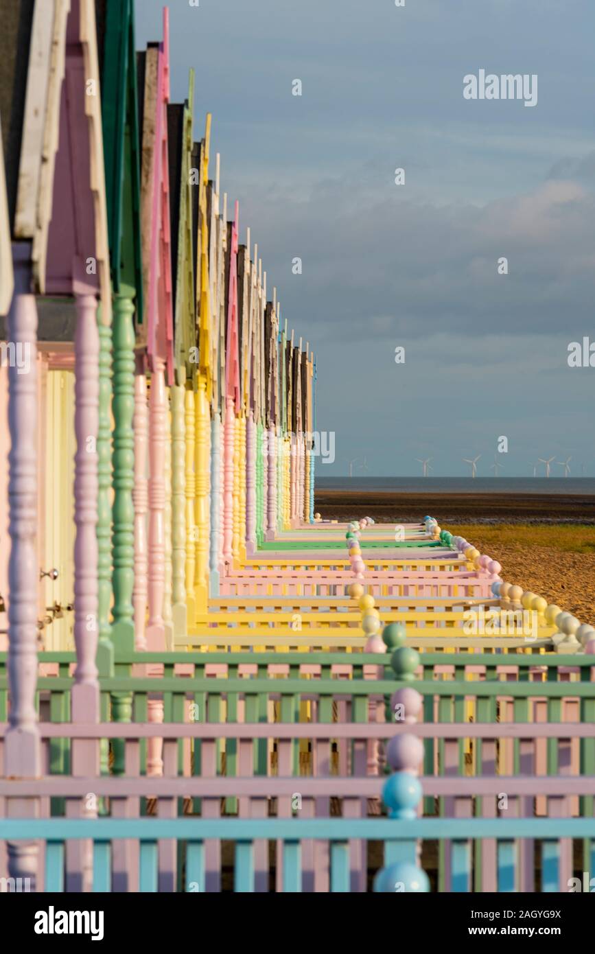 In legno colorato capanne sulla spiaggia a West Mersea, Mersea Island, Essex, Regno Unito durante una pausa nell'inverno. Dicembre pomeriggio. I colori luminosi e mare Foto Stock