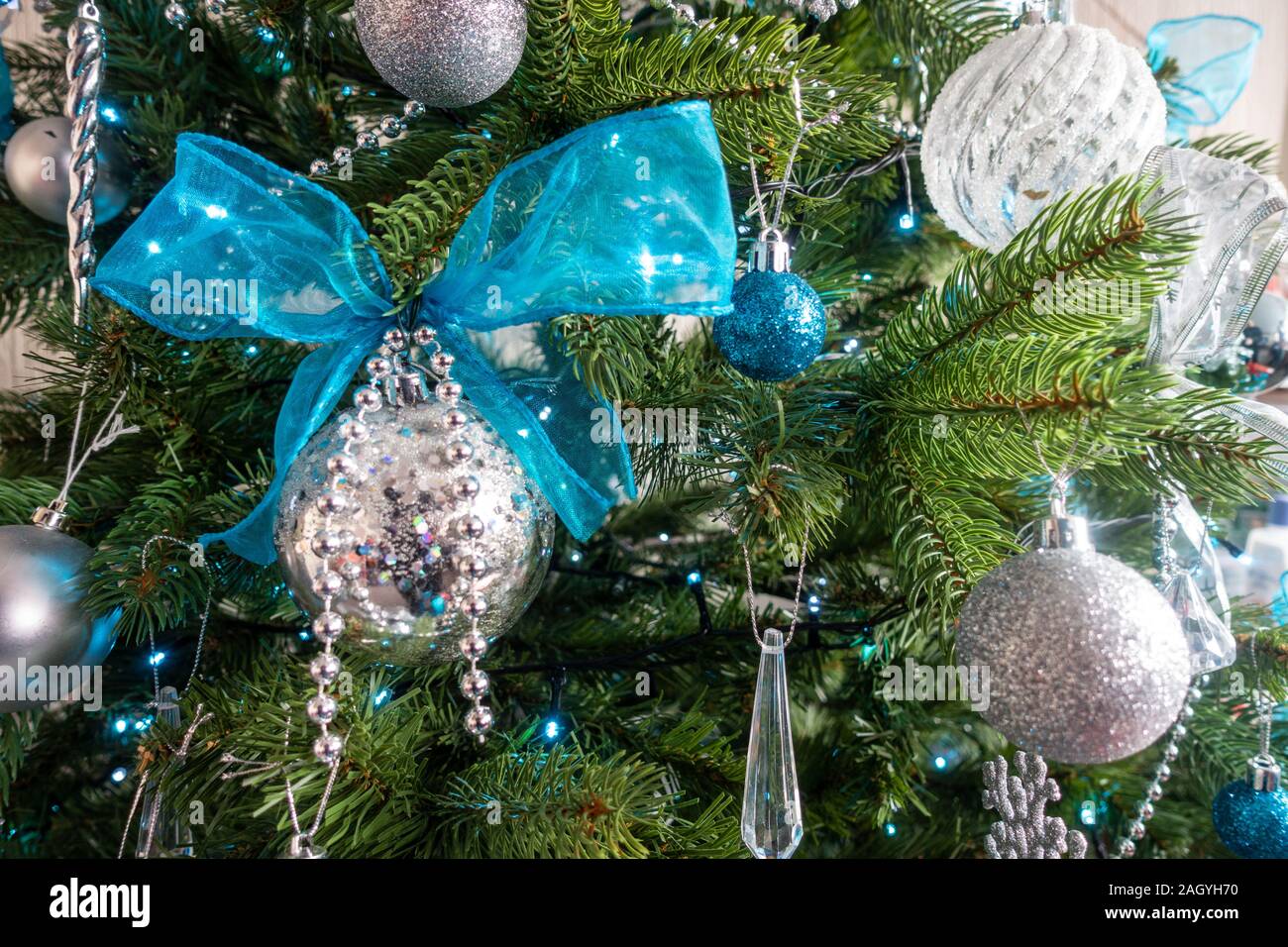 Un albero di Natale decorato con argento e decorazioni blu. Foto Stock