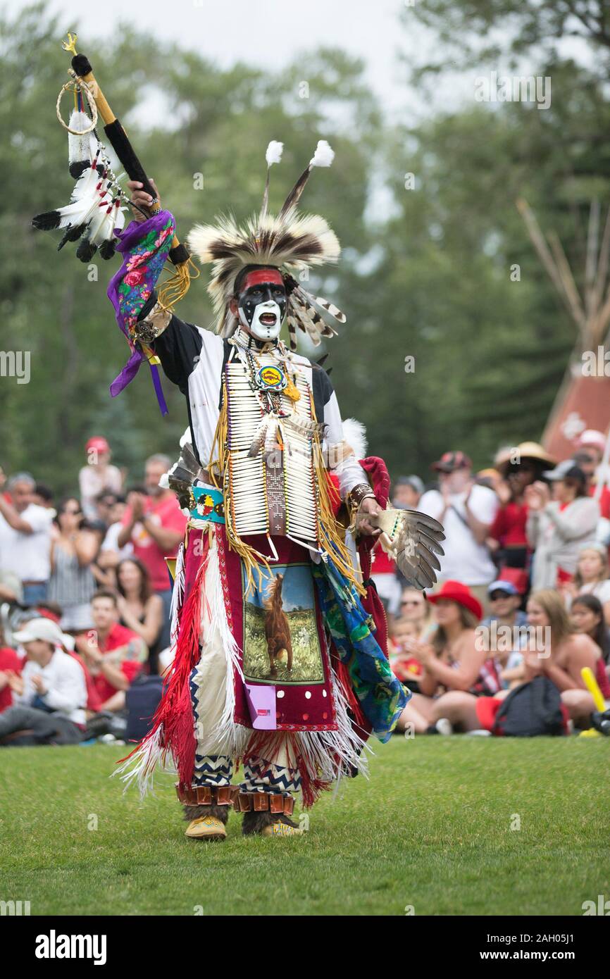 Danzatore indigeno maschile in abito tradizionale con copricapo piumato durante un powwow del Canada Day. Foto Stock