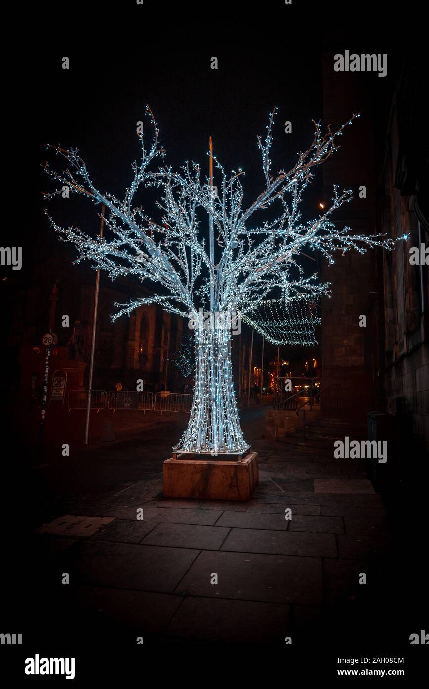 Edimburgo, Scozia, 13 dicembre 2018: sorprendente scultura di un albero con un scheletro, soddisfatto di luci di Natale splendente e incandescente nella Foto Stock