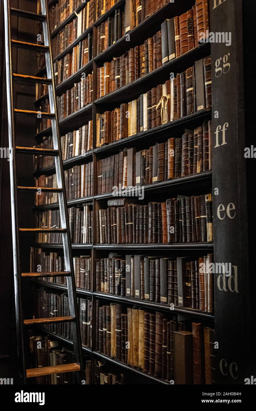 Dublino, Irlanda, dicembre 21, 2018: la sala lunga nella biblioteca del Trinity College, la casa del Libro di Kells. Una scala per raggiungere i libri a differenti Foto Stock