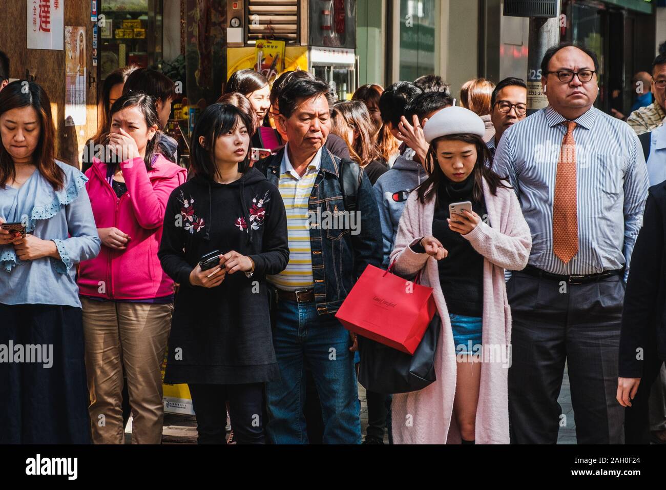 HongKong - Novembre 2019: gruppo di persone in attesa sul semaforo attraversare la strada in HongKong city, il quartiere centrale degli affari. Foto Stock
