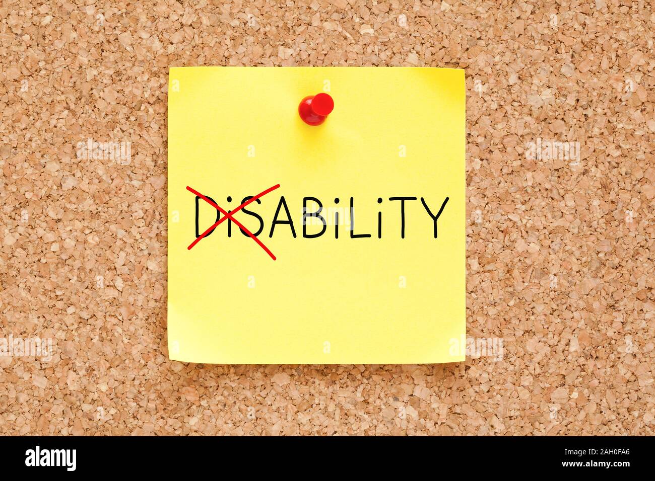 Girando la parola della disabilità nella capacità con indicatore rosso sul bigliettino giallo segnato con red spingere il perno sul sughero bulletin board. Foto Stock