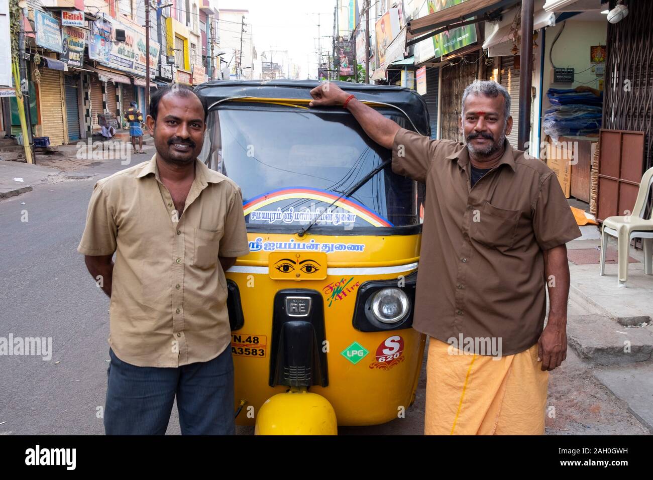 Ritratto di auto sorridente rickshaw driver permanente sulla strada Trichy, Tamil Nadu, India Foto Stock