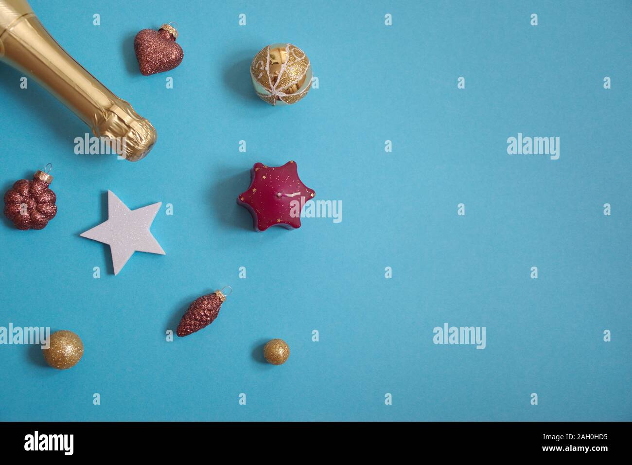 Piatto di laici della bottiglia contro lo sfondo blu glitter con ornamenti Christms Foto Stock