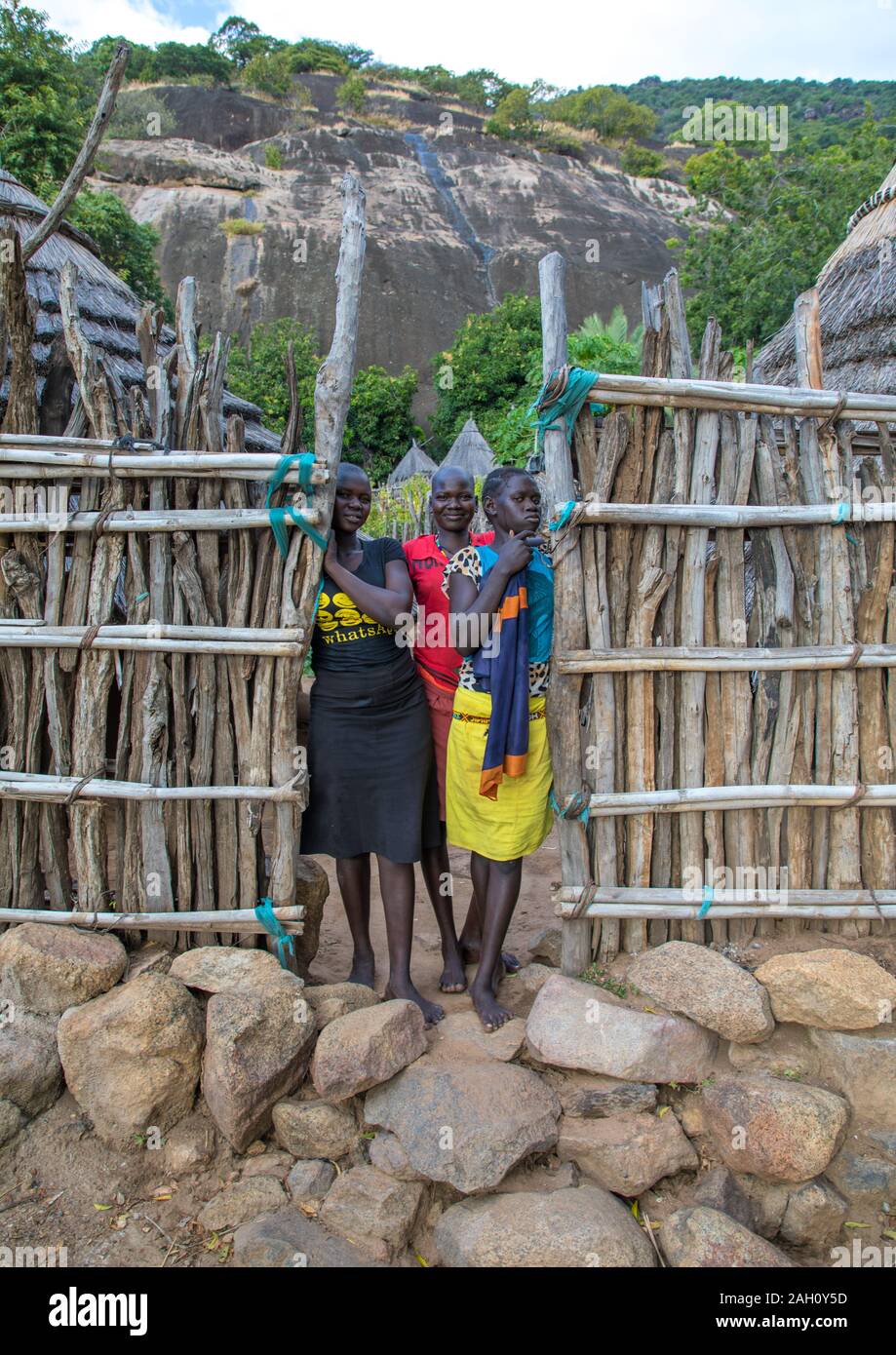 Tribù Lotuko ragazze permanente al cancello di legno di una casa, Equatoria centrale, Illeu, sud Sudan Foto Stock