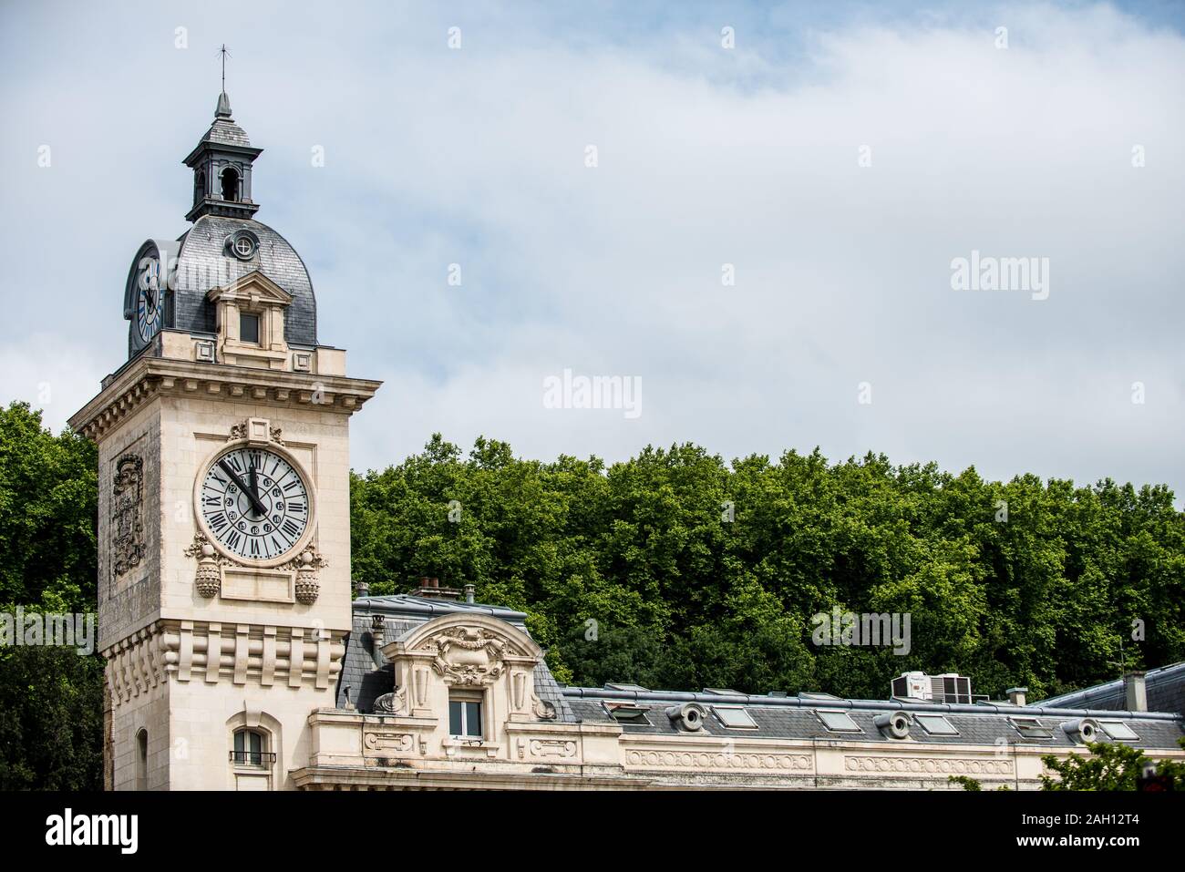 Chiesa torre con orologio contro alberi e cielo blu in background Foto Stock