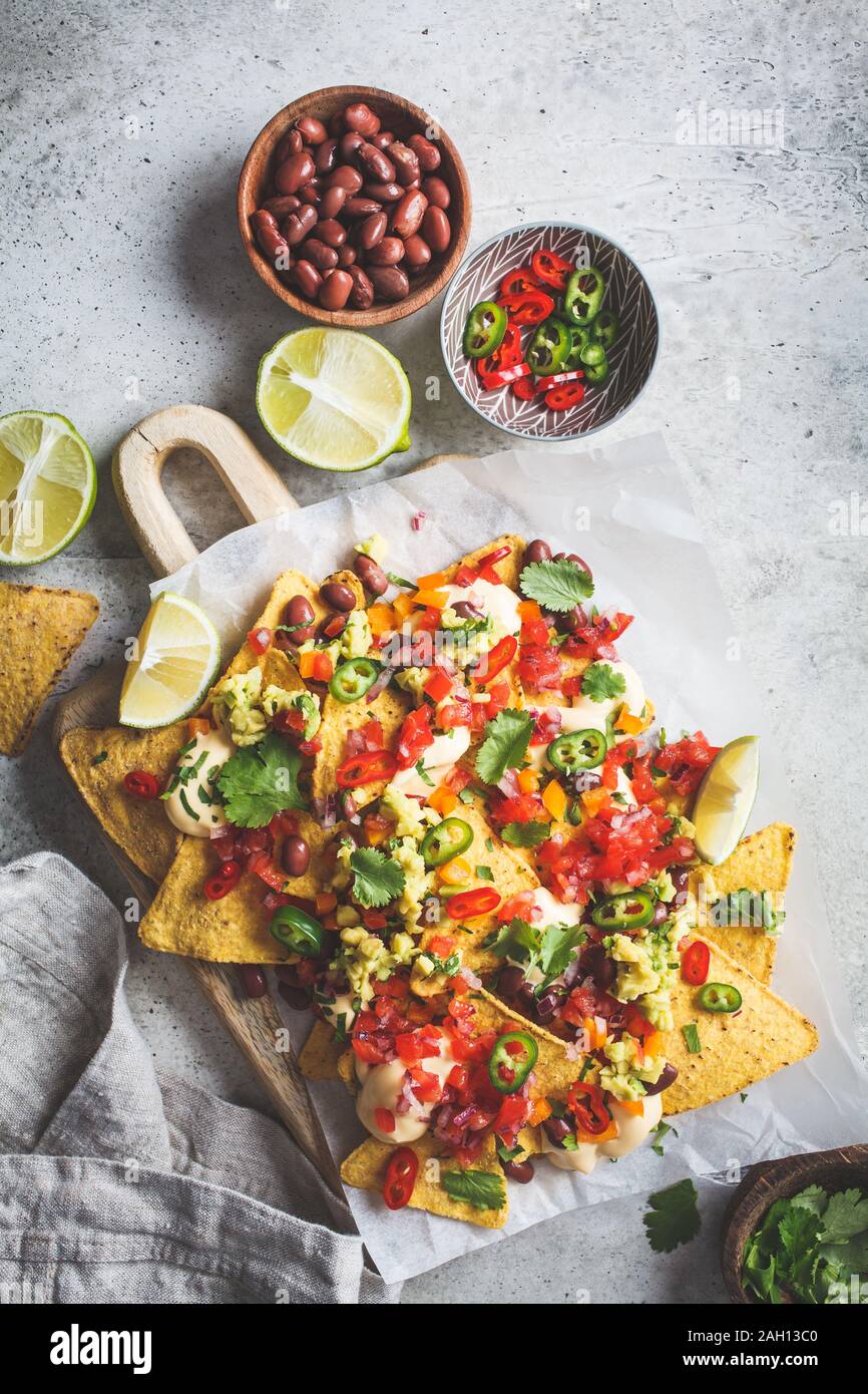 Nachos chips con salsa al formaggio, guacomole, salsa e verdure sulla scheda. Parte il concetto di cibo. Cibo messicano concetto. Foto Stock