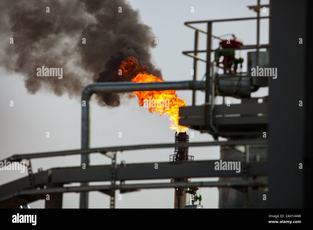 La masterizzazione di cannello a gas con il fumo nero. Trattamento dei gas e olio impianto di raffineria. Foto Stock