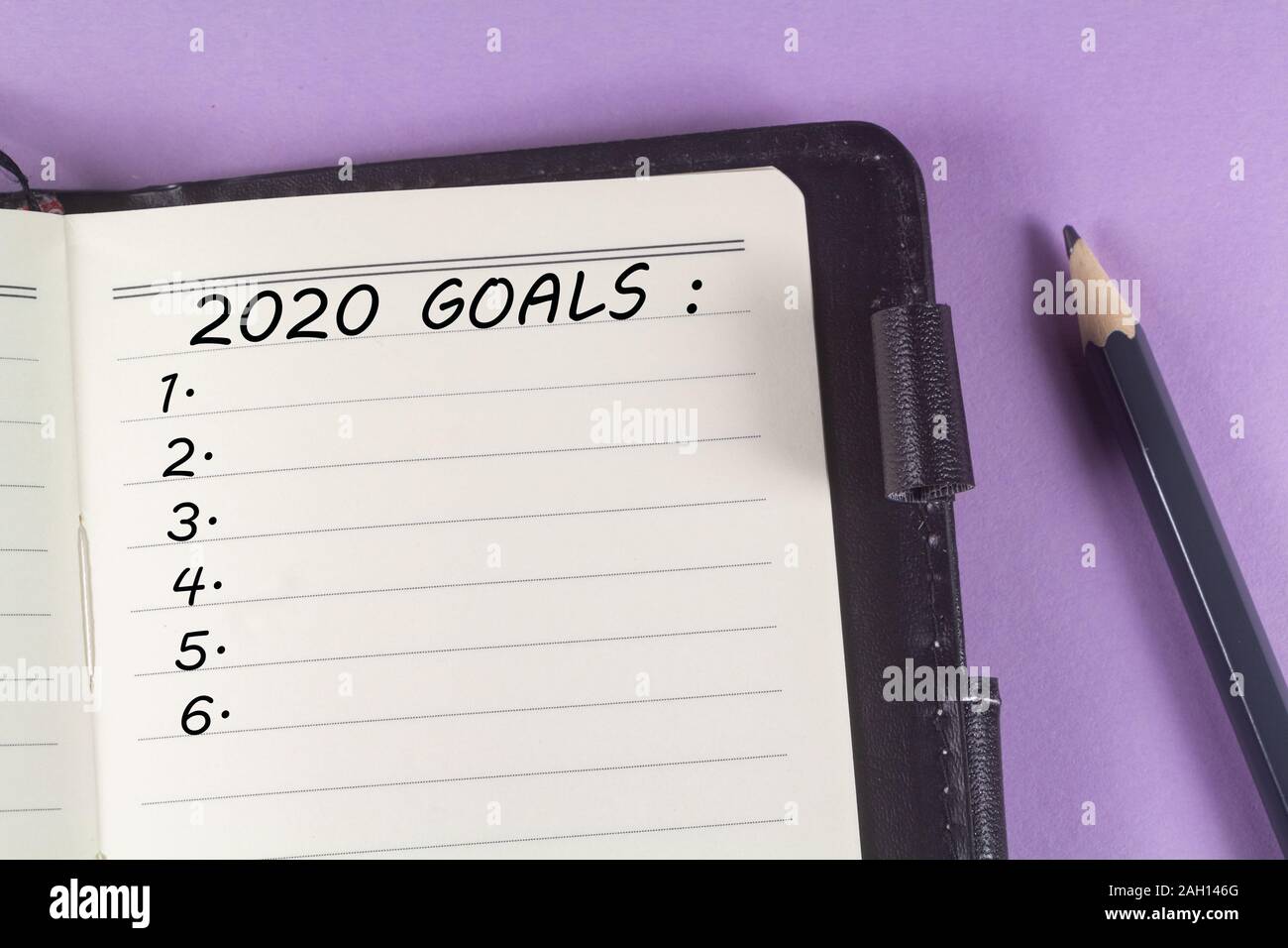 Notebook con 2020 obiettivi e matita su sfondo viola Foto Stock