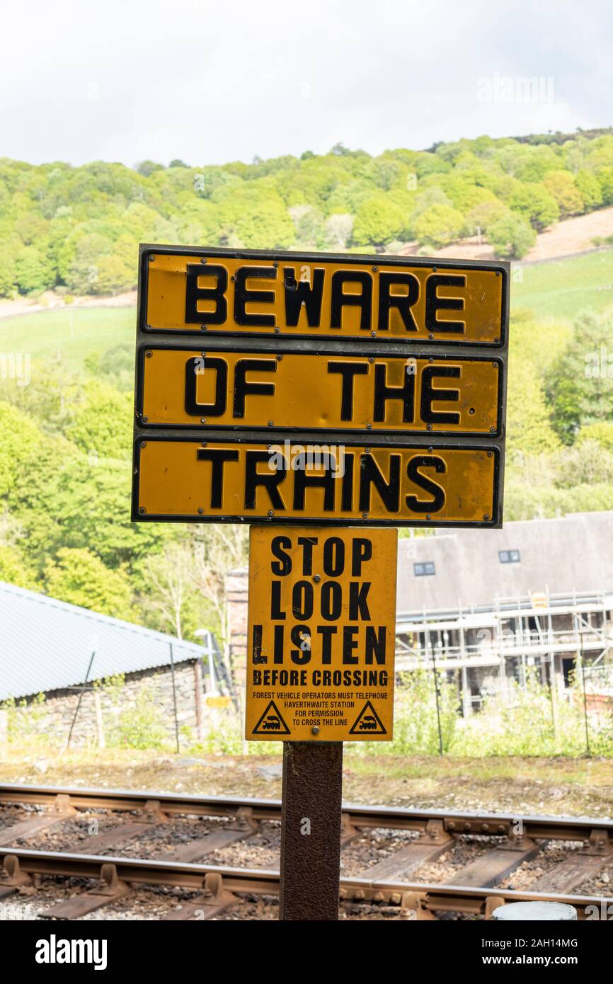 Fate attenzione al segno dei treni al lungolago e la stazione ferroviaria Haverthwaite, nel Lake District inglese Foto Stock