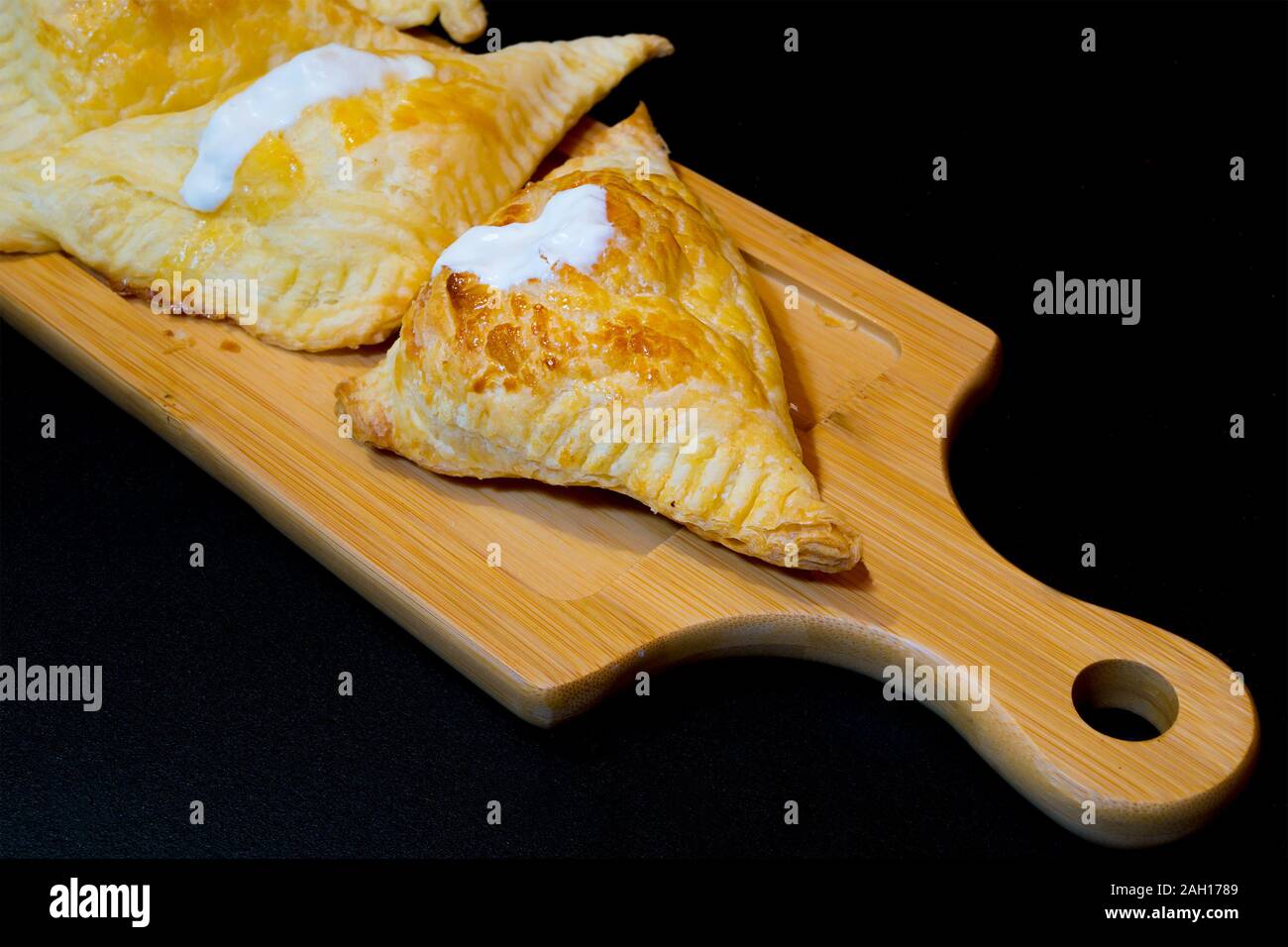 Bignè con ricotta e panna acida su un vassoio in legno Foto Stock