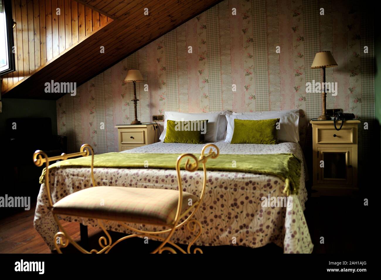 Vintage rustico tetto inclinato camera da letto con fiori pattern. Foto Stock