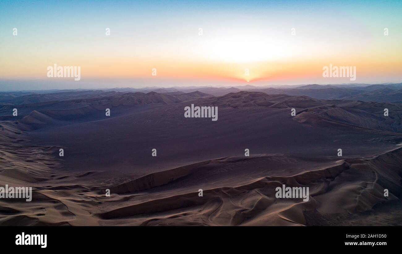 Vista aerea dalla formazione di alte dune di sabbia e profonde valli con cielo limpido all'alba nel deserto di dasht e LUT Foto Stock