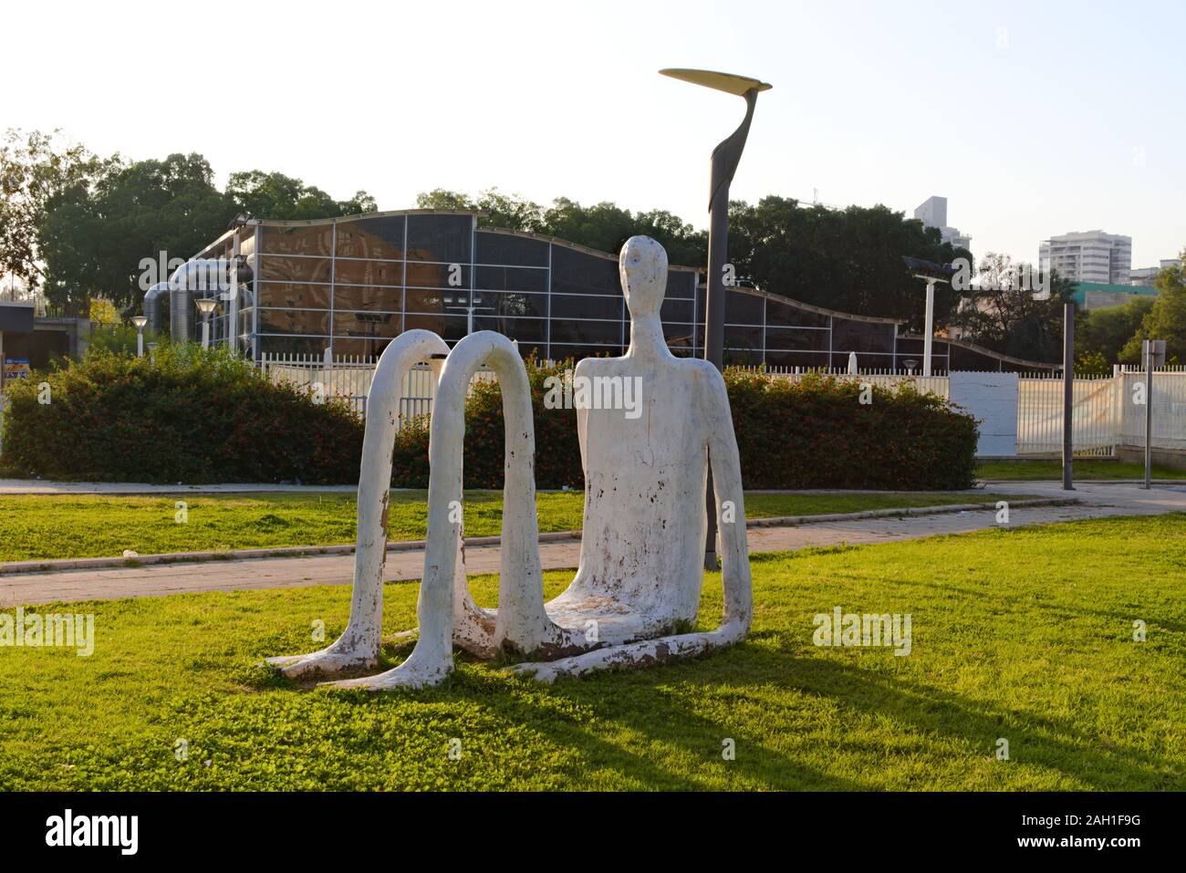 Interessante scultura di una sagoma umana seduto in erba, Qiryat Gat, Israele Foto Stock