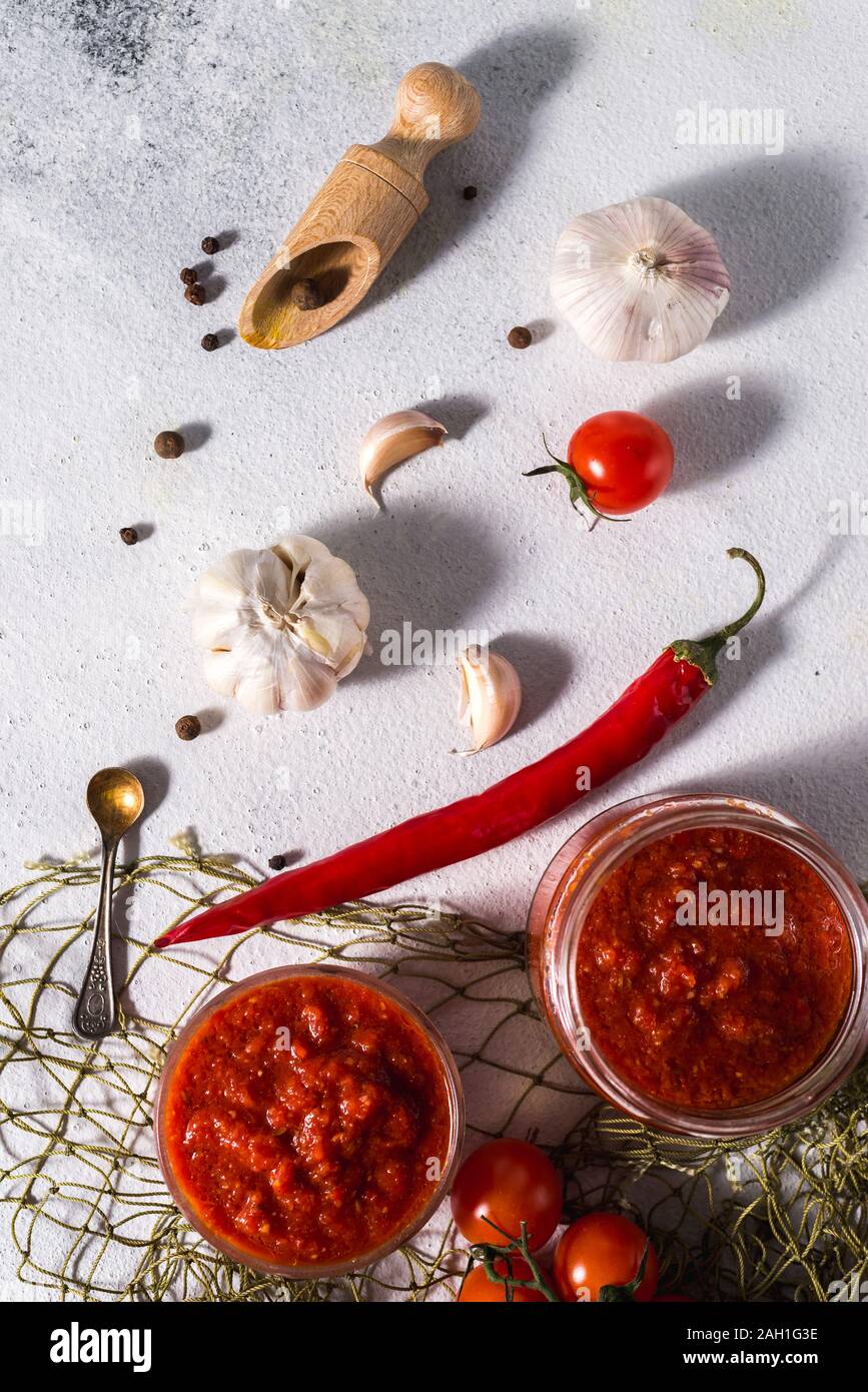 Tradizionale messicano, georgiano e arabo harissa pepe pasta su un cemento grigio Sfondo. Utile il cibo piccante Foto Stock