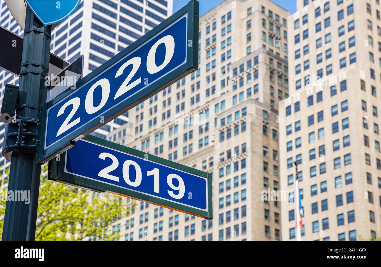 2020 Nuovo anno a anno 2019 Strade segni bivio, colore blu. Highrise sfondo di edifici Foto Stock