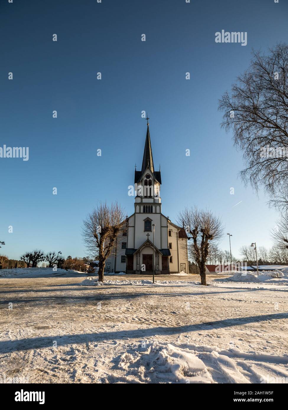 Bamble Chiesa, grande chiesa in legno costruito nel 1845. L'inverno, la neve, il cielo blu. Vista frontale. L'immagine verticale. Foto Stock