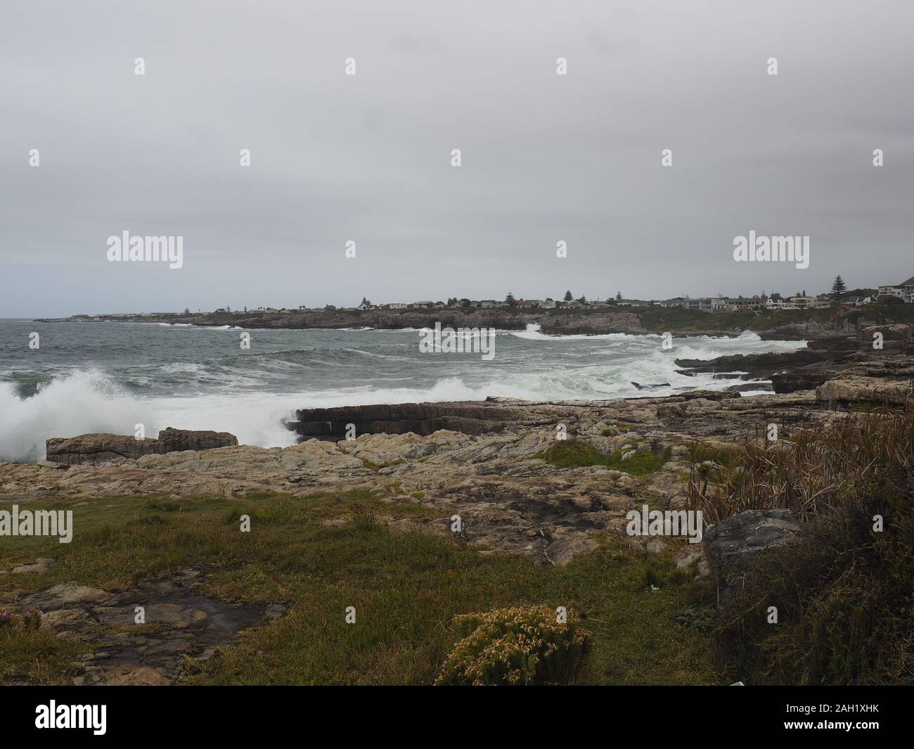 Onde che si infrangono nelle rocce da una città di mare Foto Stock