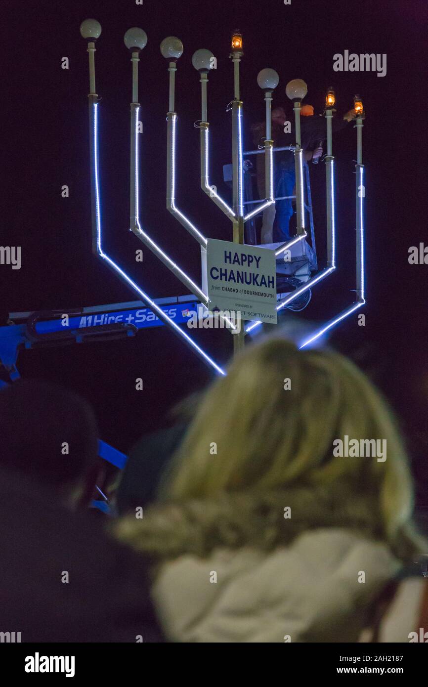 Bournemouth Dorset, Regno Unito. 23 dic 2019. Giant Menorah illuminazione a Chanukah (Hanukkah) la celebrazione in Bournemouth con la menorah acceso dal signor Jarvis Lazzaro e il Consigliere Susan Phillips, Sindaco di Bournemouth, ospite d'onore. Chanukah è il Jewish 8 giorno "festival delle luci" con una nightly menorah illuminazione, speciali preghiere e alimenti fritti. Credito: Carolyn Jenkins/Alamy Live News Foto Stock