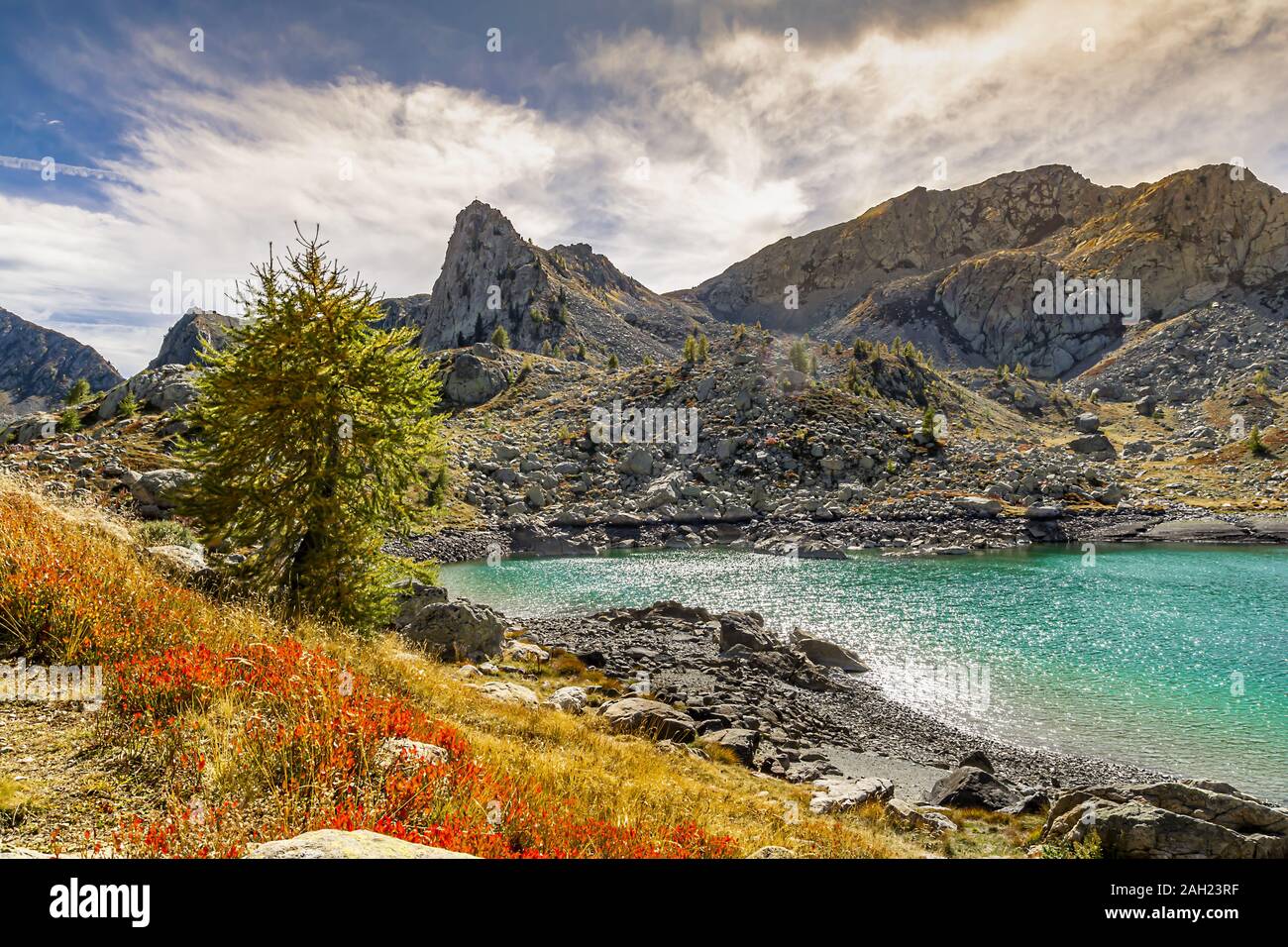 I colori dell'autunno, dominata dal rosso dei mirtilli, il blu intenso del cielo e il verde smeraldo delle acque dei laghi alpini Foto Stock