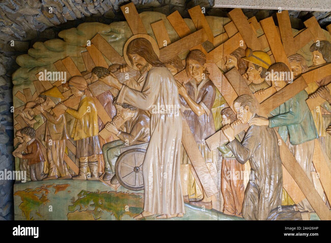Un rilievo di intaglio in legno di Gesù che porta la croce insieme con le persone in tutti gli ambiti della vita. Il Santuario di Nostra Signora di Tylicz. Foto Stock
