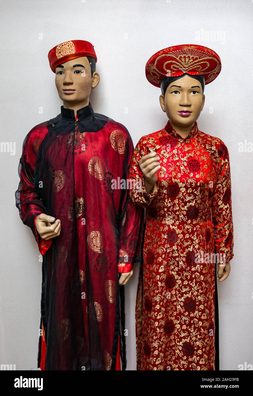 I modelli presentano indossando il tradizionale stile Cinese di seta rosso accappatoi, Thai Nguyen museo di etnologia, nel Vietnam del Nord, Asia Foto Stock