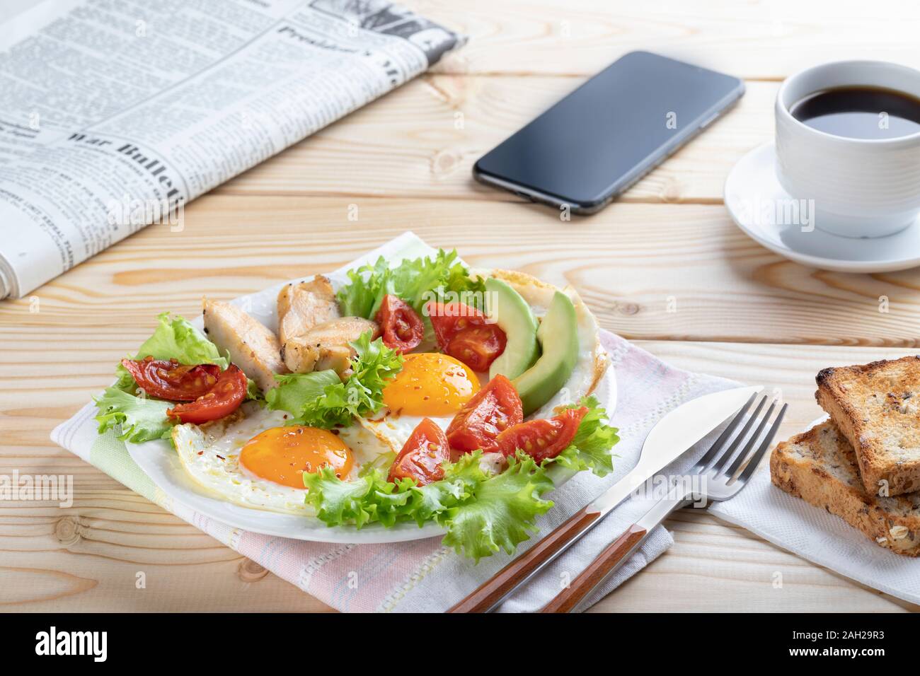 Una sana prima colazione di lavoro in unione o in stile americano con uova fritte, verdure ed erbe aromatiche. Close up Foto Stock