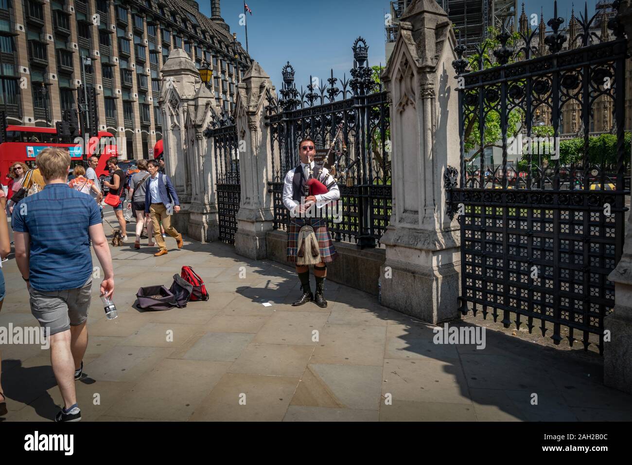 Un uomo suona la cornamusa davanti alla Casa del Parlamento e dal Big Ben di Londra, Regno Unito, GB, Inghilterra Foto Stock