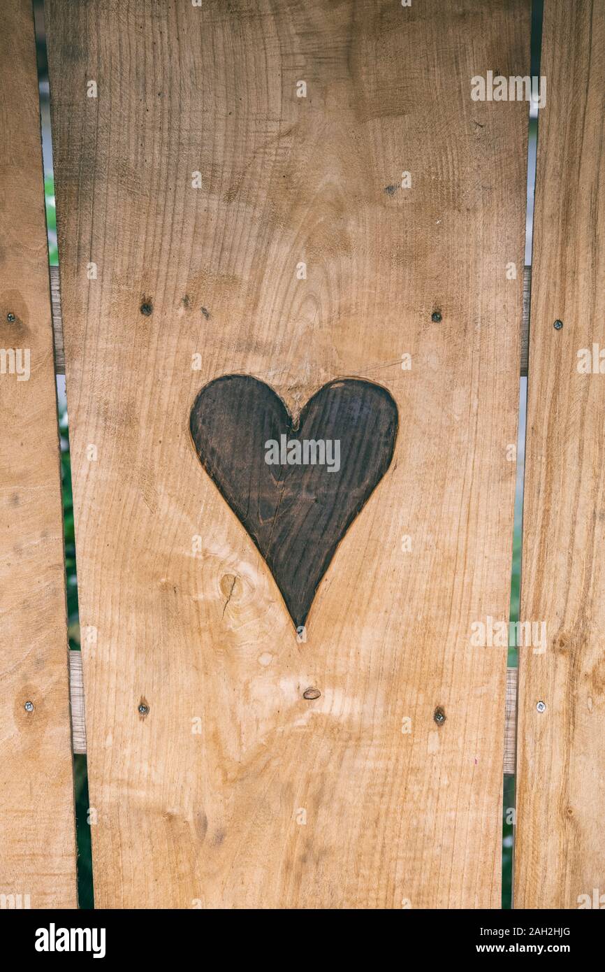 Cuore scolpito su un sedile in legno Foto Stock