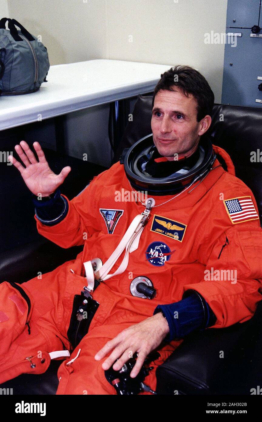 STS-81 Lo specialista di missione Jerry Linenger onde per la telecamera nel suo lancio/entry tuta e casco in camera suitup delle operazioni e checkout (O&C) edificio. Foto Stock