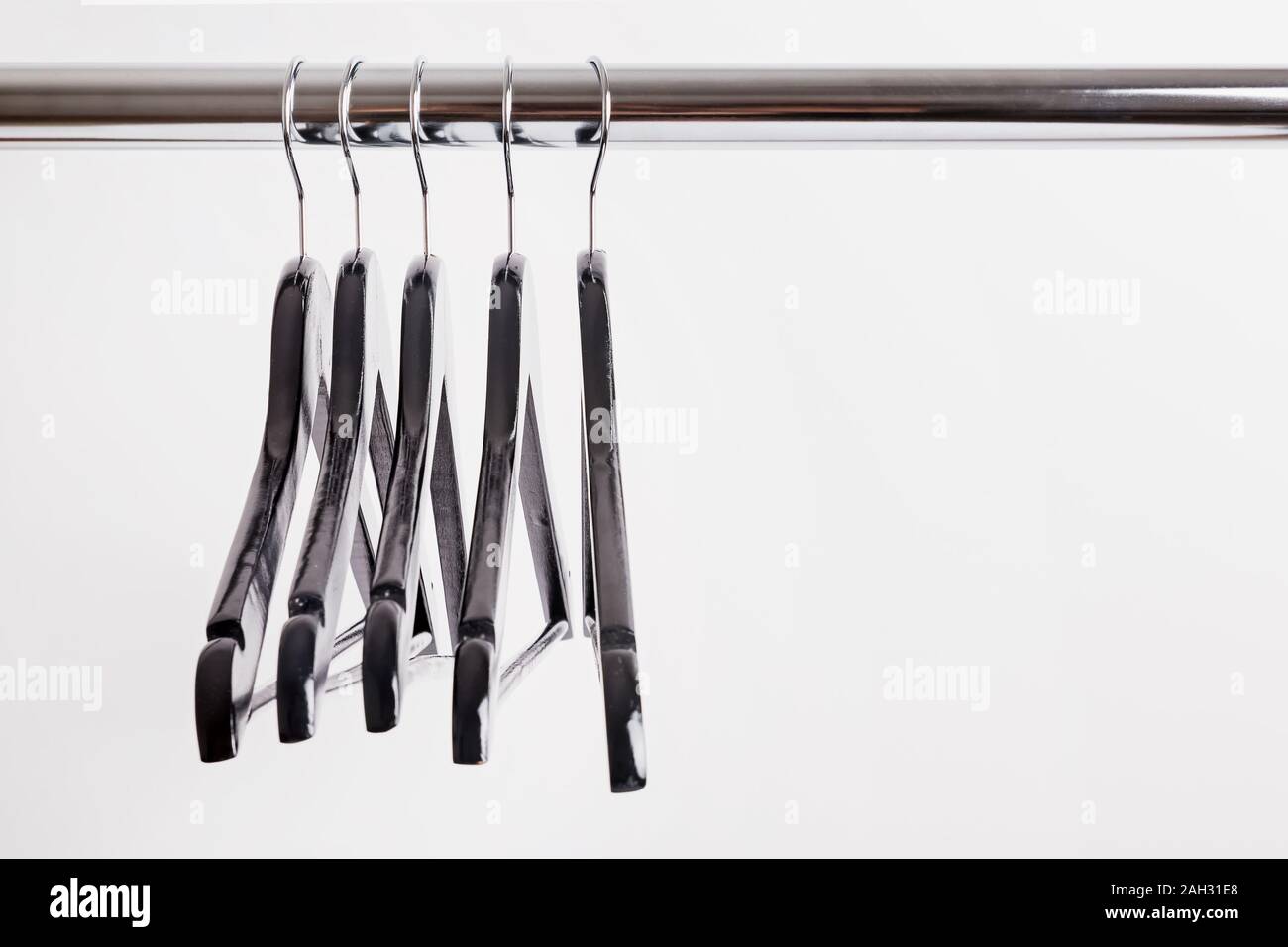 Vuoto nero appendiabiti in legno su una rotaia di close-up. Foto Stock