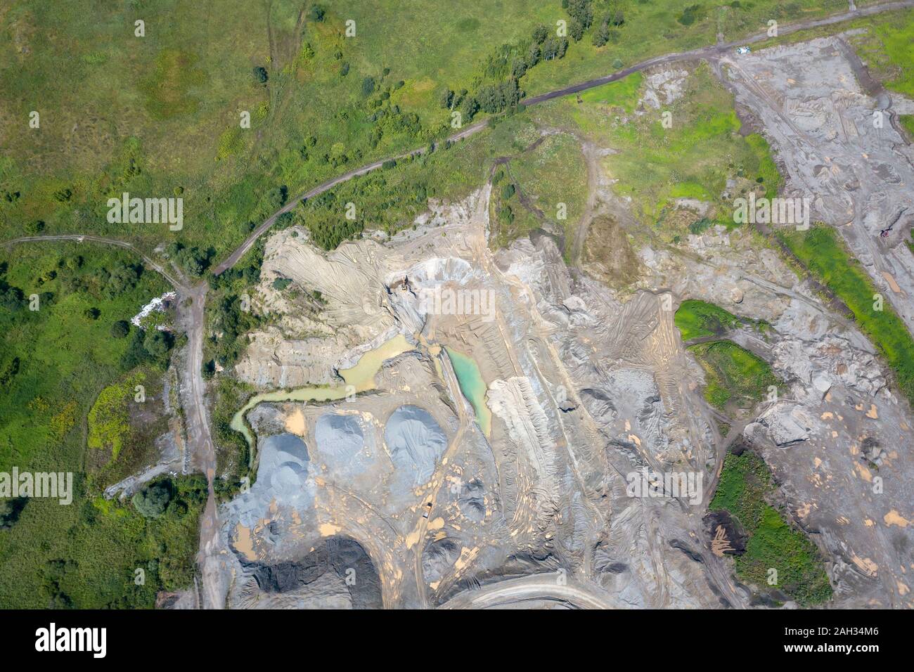Vista aerea di un piccolo impianto per la produzione e la pulizia di macerie e cemento vicino a cumuli di materiali da costruzione, i trattori ed escavatori. Minin Foto Stock