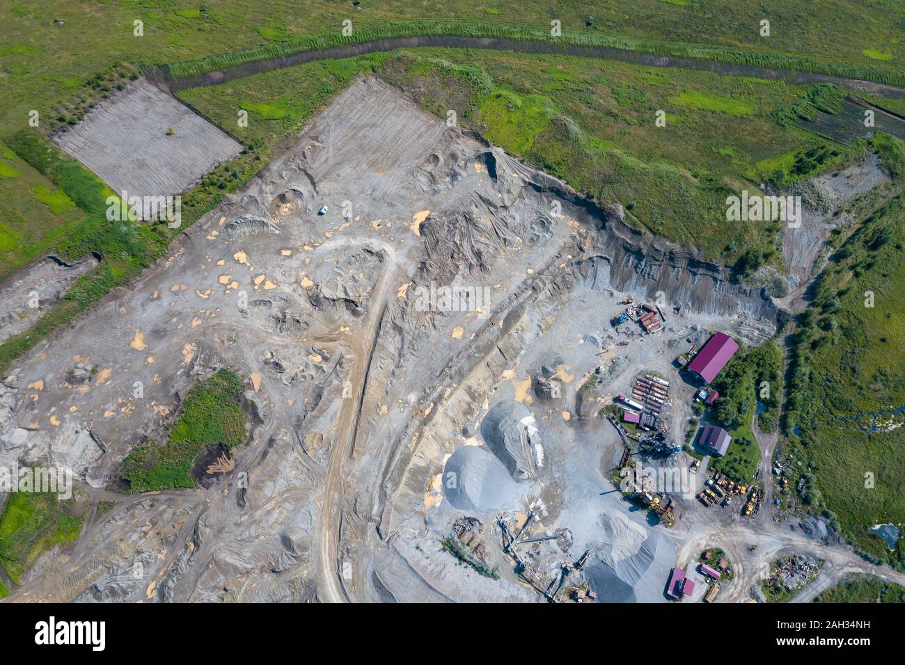 Vista aerea di un piccolo impianto per la produzione e la pulizia di macerie e cemento vicino a cumuli di materiali da costruzione, i trattori camion e trasporto Foto Stock