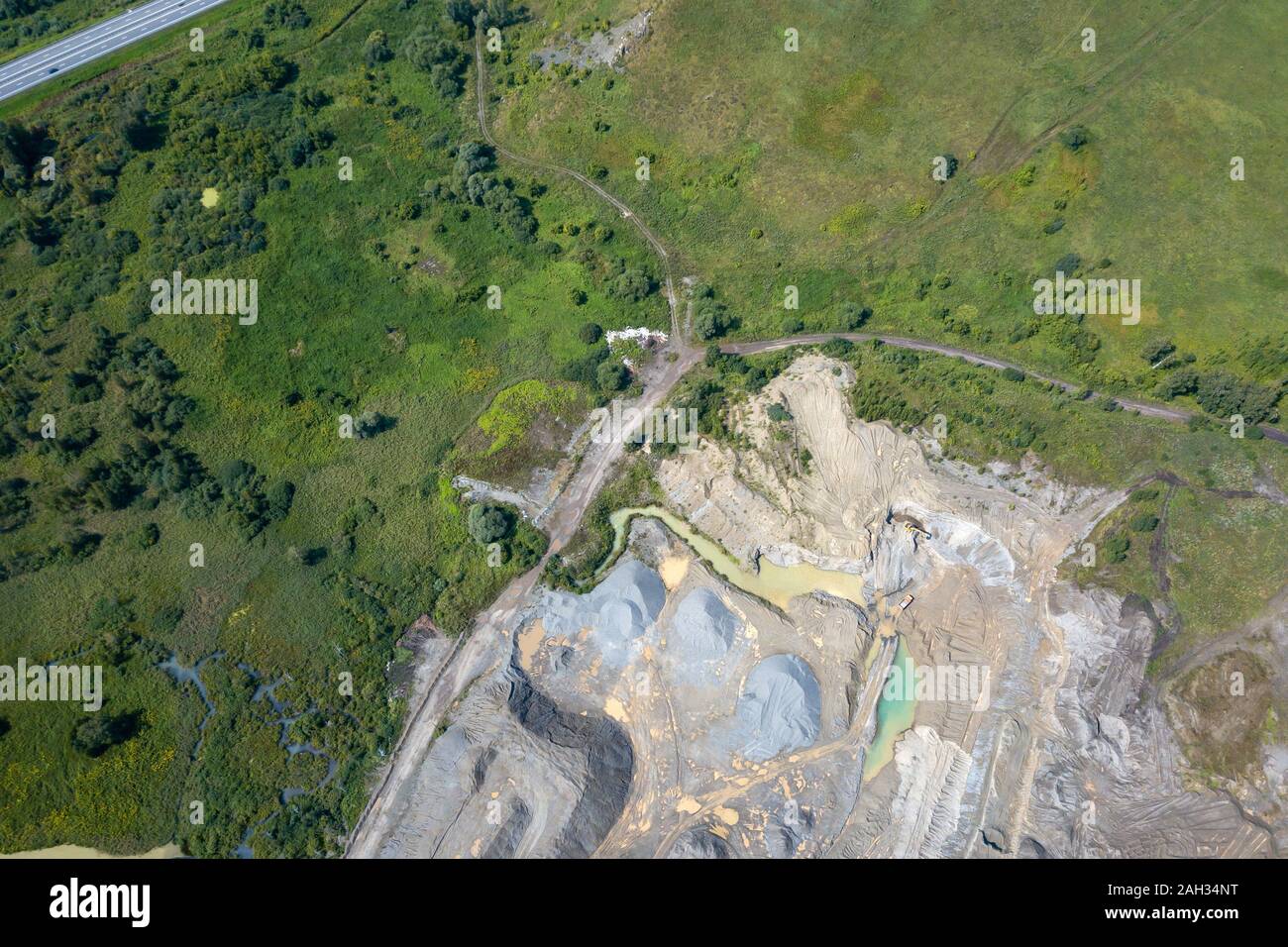 Vista aerea di un piccolo impianto per la produzione e la pulizia di macerie e cemento vicino a cumuli di materiali da costruzione, i trattori camion e trasporto Foto Stock