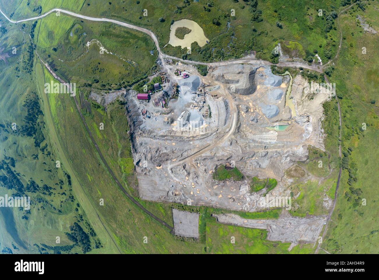 Vista aerea di un piccolo impianto per la produzione e la pulizia di macerie e cemento vicino a cumuli di materiali da costruzione, i trattori camion e trasporto Foto Stock