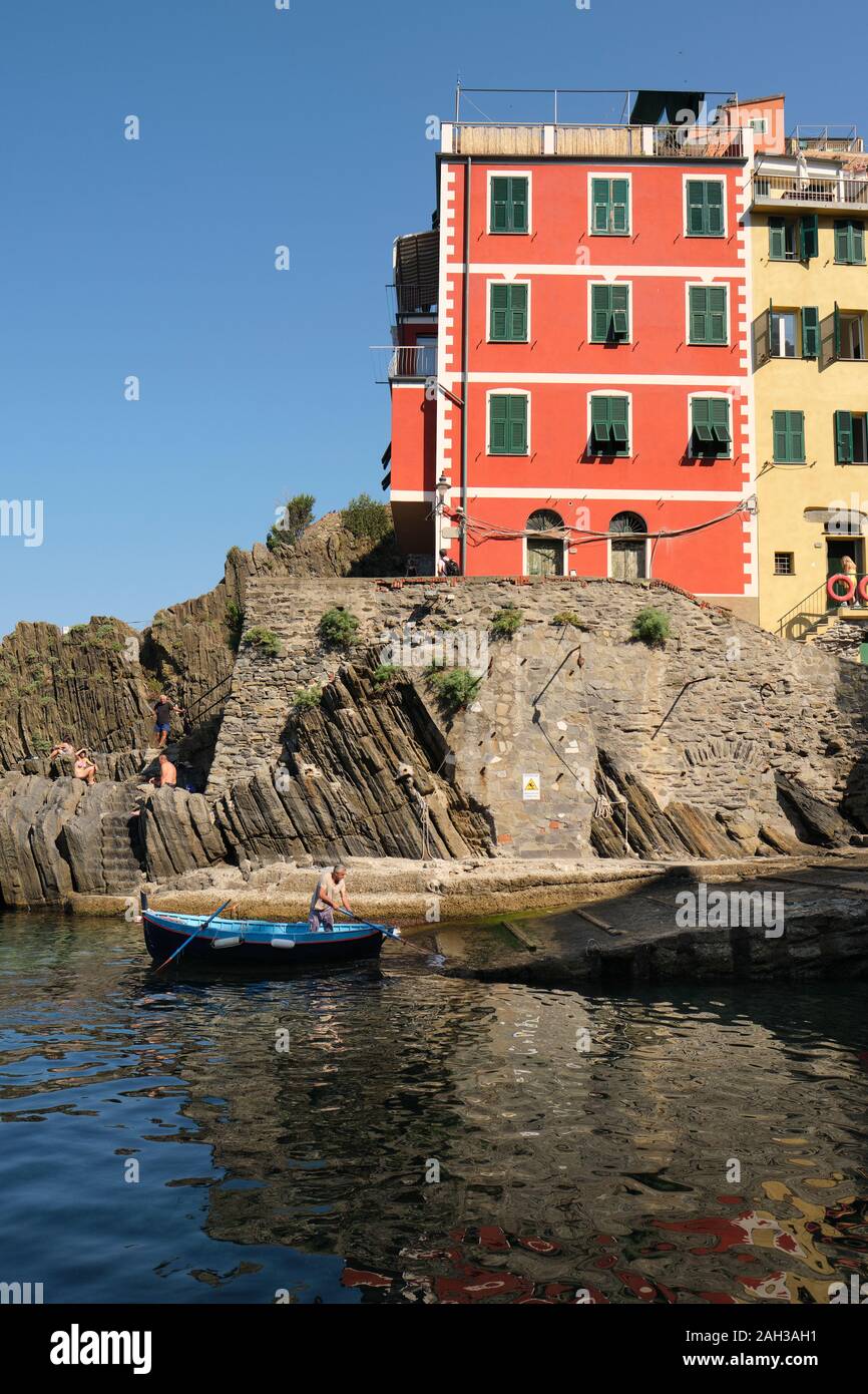 Il colorfully case dipinte e pescatore locale nel villaggio porto di Riomaggiore all'alba, e il Parco Nazionale delle Cinque Terre Liguria Italia EU Foto Stock