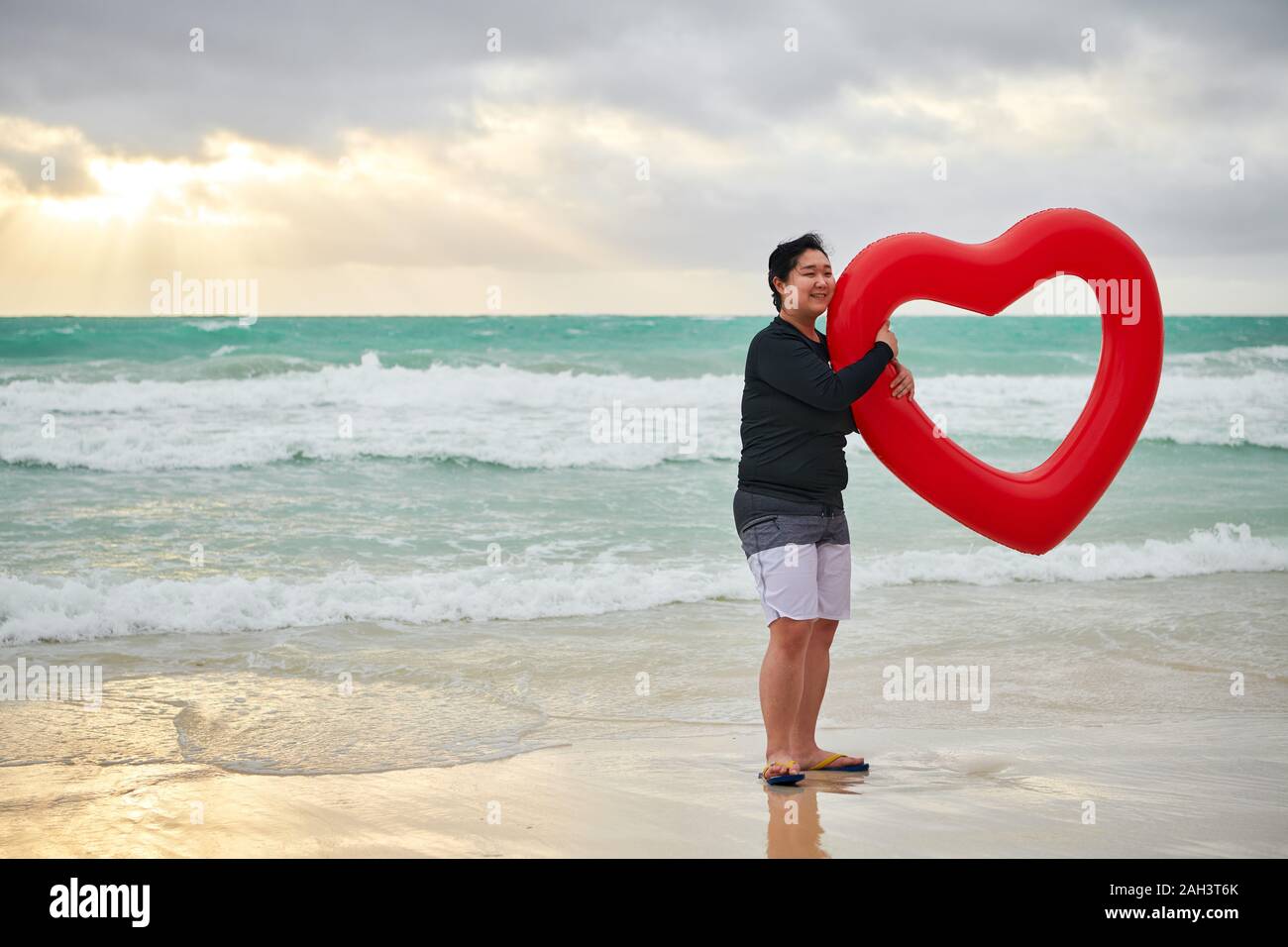 Il Boracay, Aklan Provincia, Filippine - 3 Dicembre 2019: una giovane donna cinese è in possesso di un rosso a forma di cuore ad anello ad aria al vuoto spiaggia bianca Foto Stock